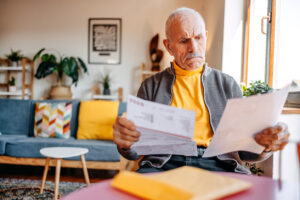 Senior man in living room going through home finances