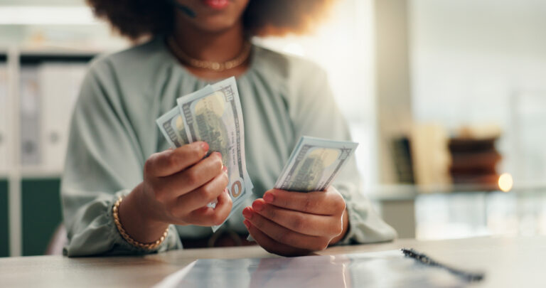 Woman counting cash after selling an annuity